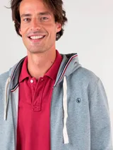 Sudadera gris con capucha ajustable con cordones blancos, cierre frontal con cremallera, bolsillos tipo canguro y logo bordado en el pecho.