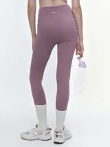 Calza deportiva de tiro alto en color violeta, confeccionada en tejido técnico elástico de alta compresión, con costuras reforzadas y diseño ajustado al cuerpo.