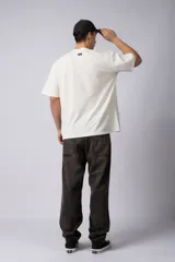 Remera de corte oversize confeccionada en algodón pesado con textura de micropanal. Presenta un diseño minimalista con un pequeño bordado lineal de un sol en el centro del pecho.