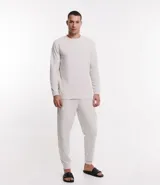 Pijama largo de hombre confeccionado en fleece texturizado color crudo. Incluye remera de manga larga con cuello redondo y pantalón jogger con cintura elástica, cordón de ajuste y bolsillos laterales.