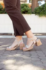 Sandalias de cuero color beige con plataforma baja, taco ancho y tira ajustable en el tobillo.