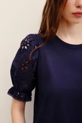 Remera fucsia con mangas abullonadas de broderie estilo globo, con cuello redondo y diseño liso en el cuerpo.