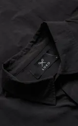 Chaqueta técnica liviana de microfibra con acabado mate, diseño con mangas desmontables que permiten convertirla en chaleco. Cuenta con cuello tipo camisa, cierre frontal oculto, cuatro bolsillos frontales de gran tamaño y puños elásticos. Incluye logo bordado en relieve en el pecho.