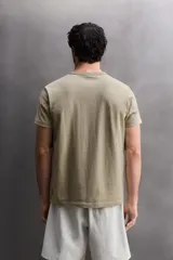 Camiseta de corte relajado confeccionada en tejido de algodón pesado, con cuello redondo y manga corta.