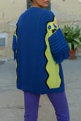 Sacón azul de algodón y acrílico con bordados de motivos tropicales en frente, espalda y mangas, y flecos en las mangas.