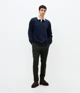 Pantalón slim de sarga lavada color marrón, con cierre de botón y cremallera, trabillas para cinturón y bolsillos laterales y traseros.