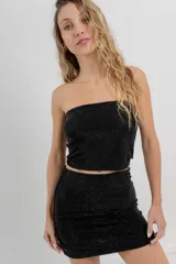 Top strapless confeccionado en tejido elástico con apliques de strass que aportan un efecto brillante tipo glitter. Silueta al cuerpo, calce cómodo y sin cierre.