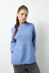 Sweater celeste de punto con cuello alto y aberturas laterales.