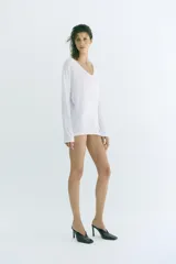 Camiseta blanca de algodón con escote en V y mangas largas, corte holgado y diseño oversize.