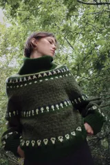 Jersey de punto con cuello subido y manga larga, diseño de jacquard con motivos geométricos en tonos verdes y crema.