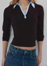 Chaleco de punto grueso color marrón, con diseño entallado, cuello camisero celeste en contraste y mangas largas.