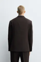 Blazer de corte regular confeccionado en tejido con lana, color marrón oscuro. Presenta cuello con solapas de muesca, cierre frontal de un botón, bolsillos con solapa en la cadera y bolsillo de vivo en el pecho.