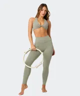 Top deportivo Fabletics modelo PureLuxe color verde militar, con diseño cruzado en la parte delantera y tirantes halter.