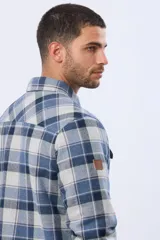 Campera tipo leñadora de viyela a cuadros, con interior forrado en corderito para mayor abrigo. Presenta cierre frontal con botones, cuello clásico y dos bolsillos frontales con solapa y botón.