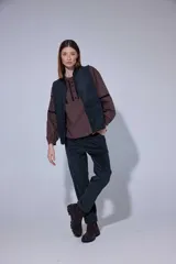 Chaleco de pana color bordó, con cierre frontal de botones y bolsillos laterales.