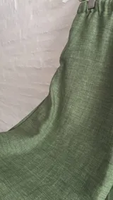 Pantalón ancho de tiro bajo, color verde claro, con cordón ajustable en la cintura y tiras laterales ajustables.