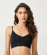Soutien top largo negro de microfibra sin aro ni costuras, con relleno removible, breteles finos y detalle de encaje en el escote.