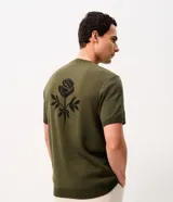 Remera de punto verde militar de manga corta y cuello redondo, elaborada en jacquard. Presenta un diseño de rosa en contraste en la espalda.