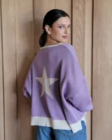 Buzo de punto color lila, con cuello redondo y ribete blanco. Presenta una estrella blanca grande en la espalda y un dobladillo blanco.