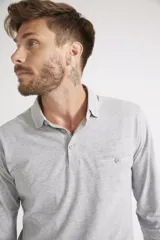 Remera polo de manga larga para hombre, confeccionada en algodón. Presenta un diseño de ajuste regular, con cuello clásico, cierre frontal con botones, bolsillo delantero con botón y logo bordado.