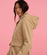 Campera alargada de Blue Steel confeccionada en polivelour, con cuello alto, capucha desmontable, cierre frontal oculto y bolsillos con solapa. Presenta un diseño minimalista y elegante con recortes delanteros.