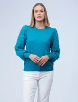 Buzo de tejido de hilado fino color celeste, marca Zac & Rachel. Mangas largas de gasa con bordado desflecado.