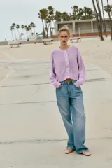 Chaqueta de punto grueso color lila con cuello redondo, manga larga, acabados en rib y cierre frontal con botones nacarados.