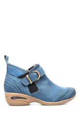 Botín de cuero celeste con elásticos laterales y hebilla decorativa. Suela de goma color caramelo con cámara de aire visible.