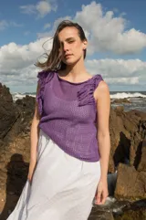 Musculosa tejida en punto calado, color violeta, con diseño sin mangas y detalle de flecos en los hombros.
