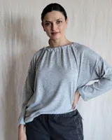 Remera de manga larga confeccionada en lanilla gris melange, con diseño holgado y escote redondo fruncido.