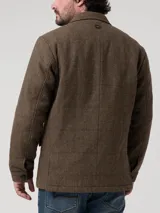 Chaqueta tipo blazer para hombre con diseño de espiga en tonos marrones. Presenta cierre frontal de tres botones, solapas clásicas y bolsillos laterales con solapa. Confeccionada con mezcla de lana y relleno térmico reciclado.