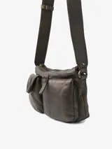 Bolso de cuero bovino color negro, con diseño urbano y versátil. Cuenta con múltiples compartimentos externos con solapa y cierre, y una correa ajustable con hebilla metálica.
