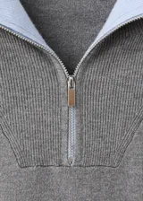 Chaleco de punto de corte recto y diseño minimalista, con cuello alto y cierre frontal de cremallera.