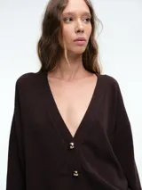 Cardigan de punto color marrón oscuro, con escote en V, manga larga y cierre frontal con botones metálicos dorados.