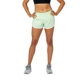 Short deportivo New Balance Accelerate de dama, color verde claro con ribetes blancos, cintura elástica y calza interior.