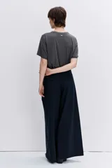 Remera de algodón color gris oscuro, con cuello redondo adornado con pedrería brillante, manga corta y corte recto.