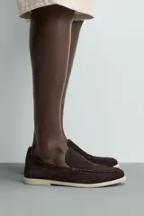 Mocasín casual para hombre confeccionado en piel con acabado en serraje, color marrón, con horma redonda, detalle de bordón y suela a contraste en tono claro.