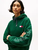 Buzo verde con capucha y cordón distintivo, bolsillo canguro, puños y bajo de punto canalé, logo oversize de Tommy Hilfiger en la manga y la parte trasera, parche con logo de Tommy Hilfiger en el pecho y detalles distintivos de Hilfiger Sailing.