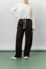 Pantalón de corte relajado y pierna recta, confeccionado en tejido tipo corderoy liviano. Presenta cintura elastizada con cordón ajustable y diseño de silueta amplia.