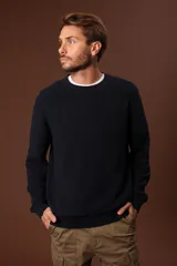 Sweater de punto en color azul marino, con cuello redondo y mangas largas con puños acanalados.