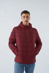 Campera puffer color bordó con capucha, cierre frontal y bolsillos laterales con cierre.