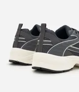 Championes estilo dad sneaker de color gris oscuro, con detalles en blanco y líneas plateadas reflectivas. Combinan malla y paneles sintéticos con una suela voluminosa blanca y negra.