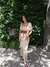 Vestido largo de dos piezas color lila con rayas verticales. El top es de corte cuadrado con mangas cortas acampanadas y elástico en la cintura. La falda es larga con volados y detalles de cuero.