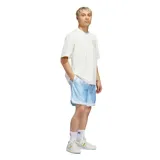Remera de algodón color blanco, de corte holgado y cuello redondo. Presenta un estampado gráfico circular en el pecho y en la espalda con el logo de Adidas y motivos de básquet en tonos celestes y amarillos.