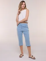 Capri de denim blanco con pretina ancha elastizada, tiro alto, bolsillos simulados al frente y bolsillos funcionales en la parte posterior, con pequeños tajos laterales en el bajo.