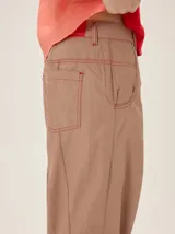 Pantalón de lyocell color tostado, con silueta relajada, bolsillos laterales y detalles de costuras pespunteadas. Cuenta con puños ajustables en los tobillos mediante cordones y elástico.