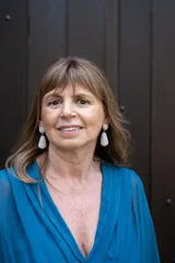 Aretes colgantes de mujer, estilo lágrima, completamente cubiertos de pequeñas piedras brillantes, posiblemente simulando diamantes o cristales. Tienen un poste superior redondo y una sección colgante en forma de gota alargada.