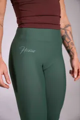 Calza deportiva larga de tiro alto en color verde militar, con ajuste ceñido al cuerpo y diseño sin costuras visibles, ideal para entrenamiento.