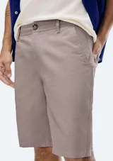 Bermuda de sarga modelo chino, color rosado, con cierre de botón y cremallera, bolsillos laterales y corte recto.