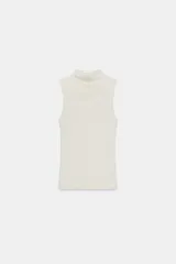 Top sin mangas, color blanco hueso, de corte ajustado y cuello alto tipo mock neck.
